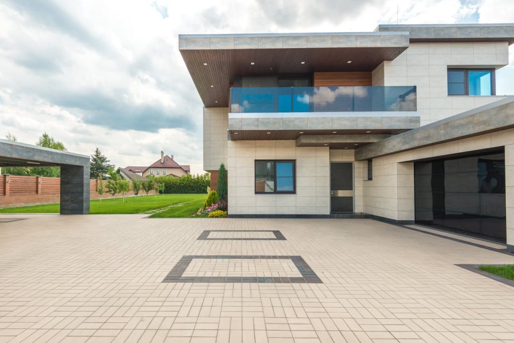 Stylish modern house featuring a sleek design with a large driveway and lush greenery.